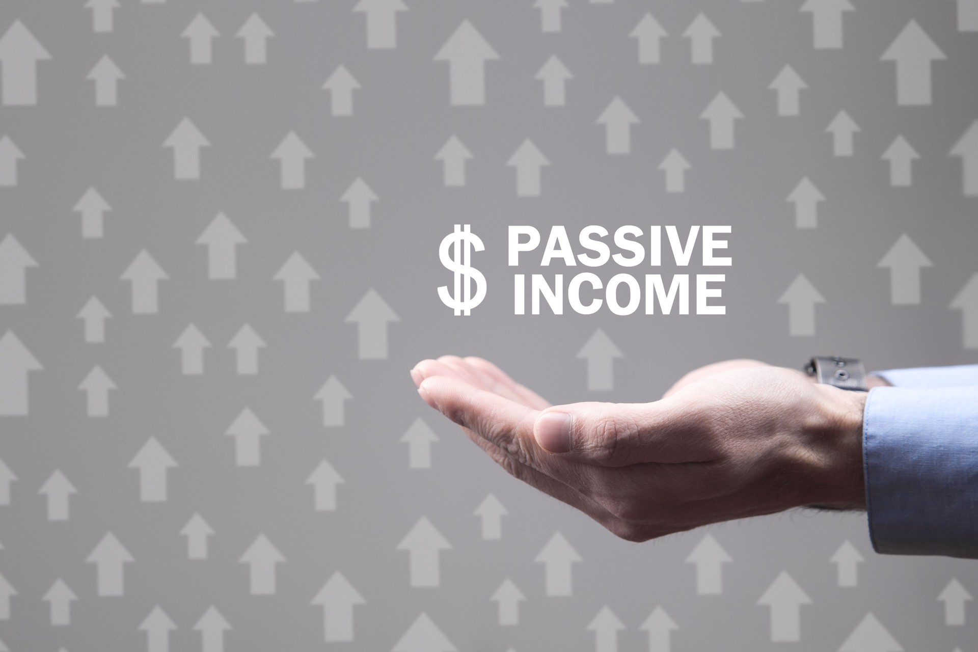 Male hands holding Passive income text with dollar symbol.